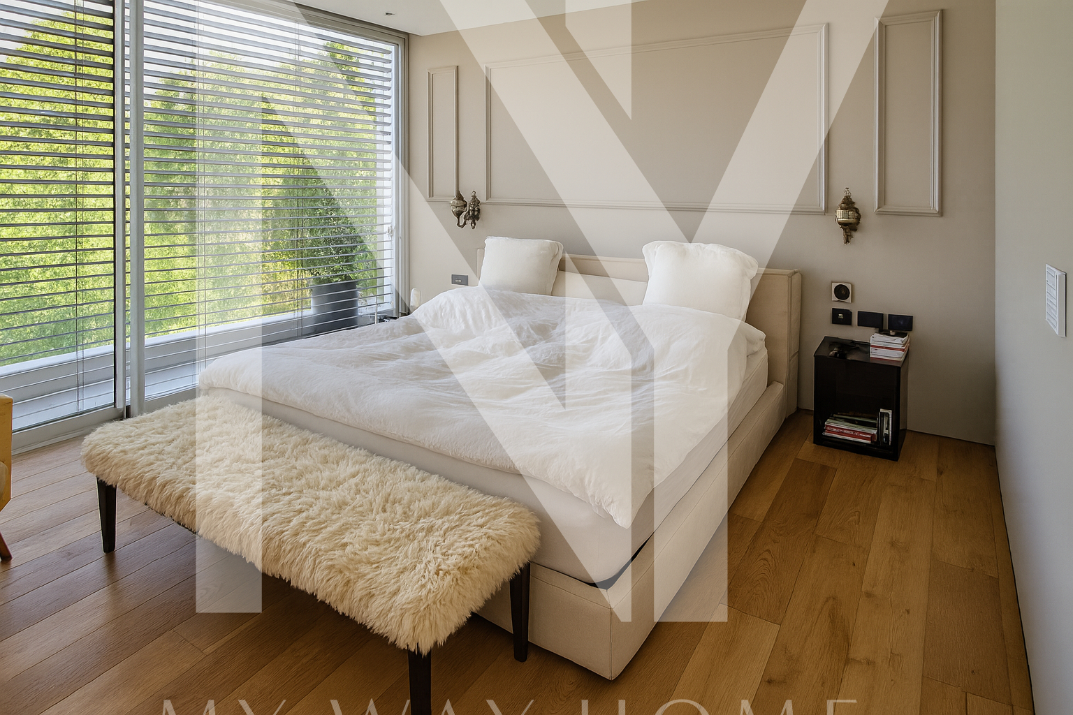 Spacious master bedroom suite with king-size bed, panoramic window, and wooden floor in South Ra’anana villa