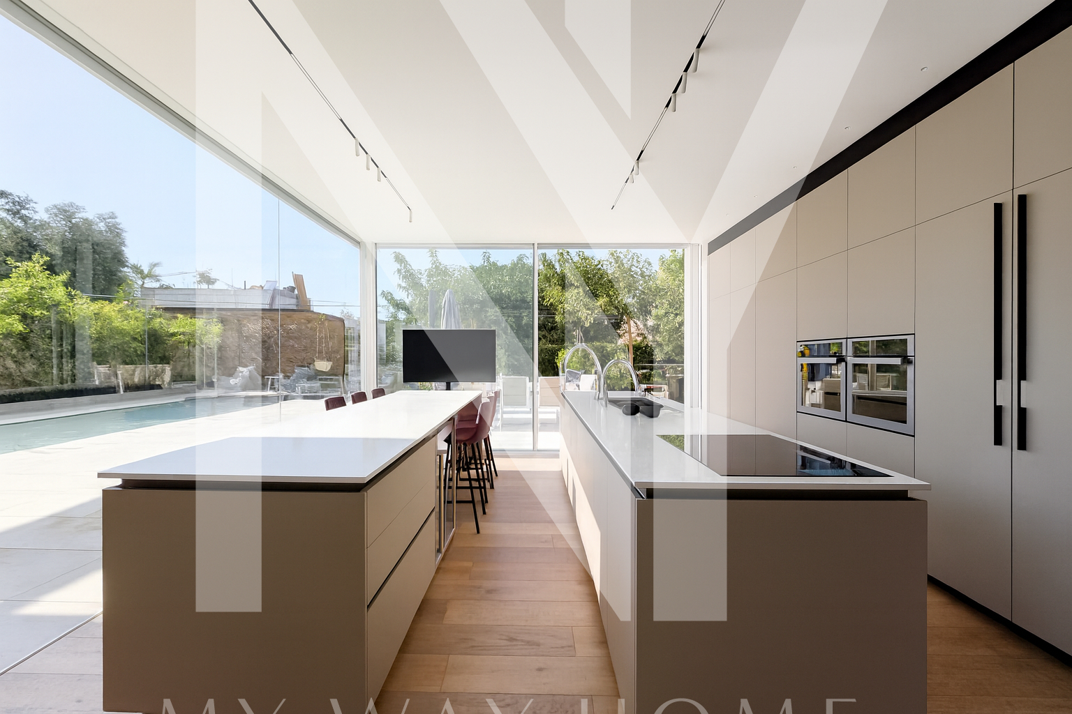 Modern kitchen with central island, white marble, and built-in appliances in Ra’anana villa for sale