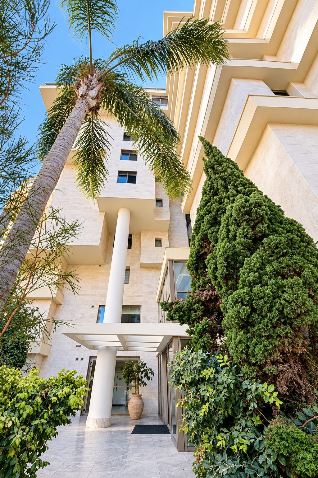 Building entrance with stone facade and palms - boutique building, Ramat Aviv, Tel Aviv
